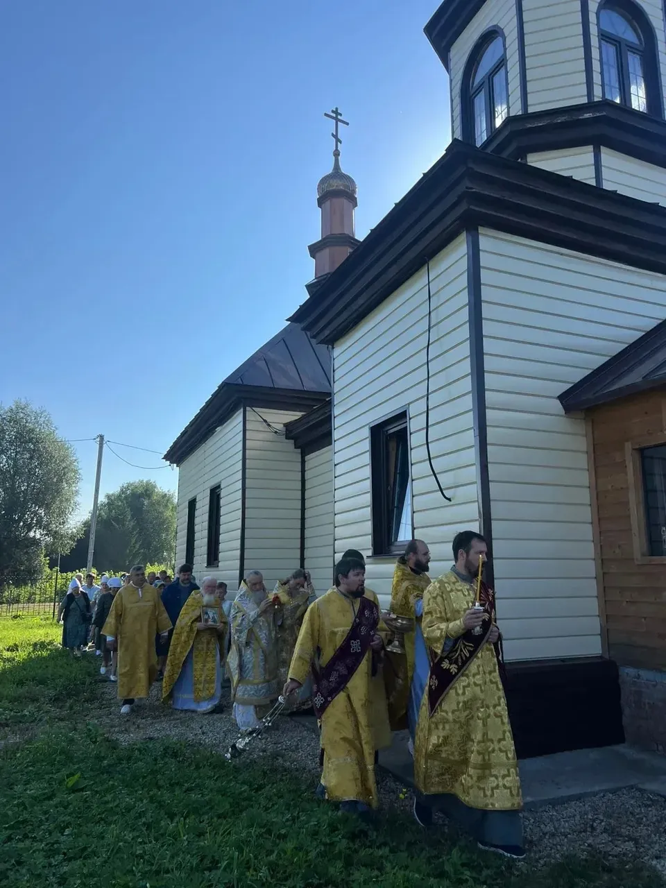 Духовенство и прихожане идут вдоль нового Никольского храма в Николаевке